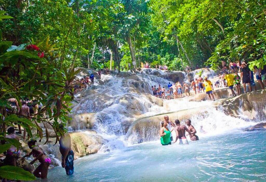 VibraGem Tours Dunn’s River Falls Tour in Jamaica with a group of people walking a human chain.